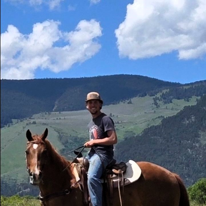 a young man on horseback in the foothills