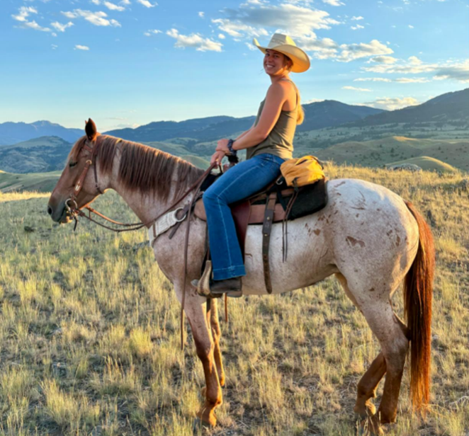a young woman on a dappled horse