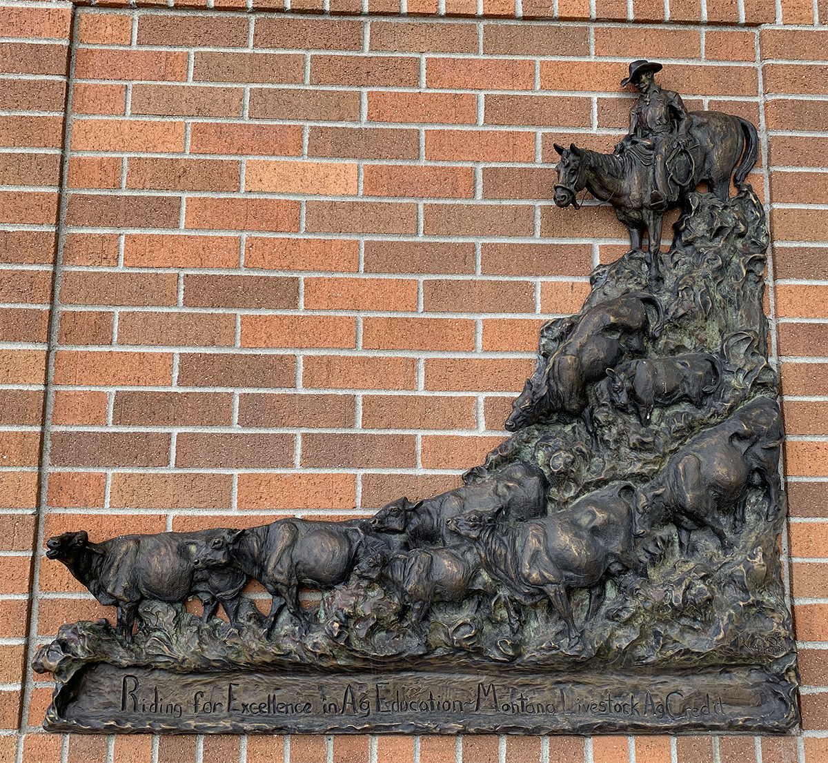 Bronze sculpture of a cattle drive on the north entrance wall of the ABB building.