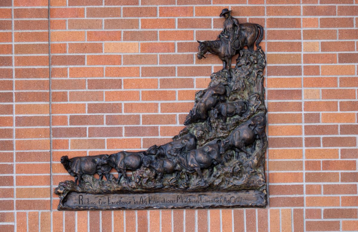 bronze western artwork on a red brick building