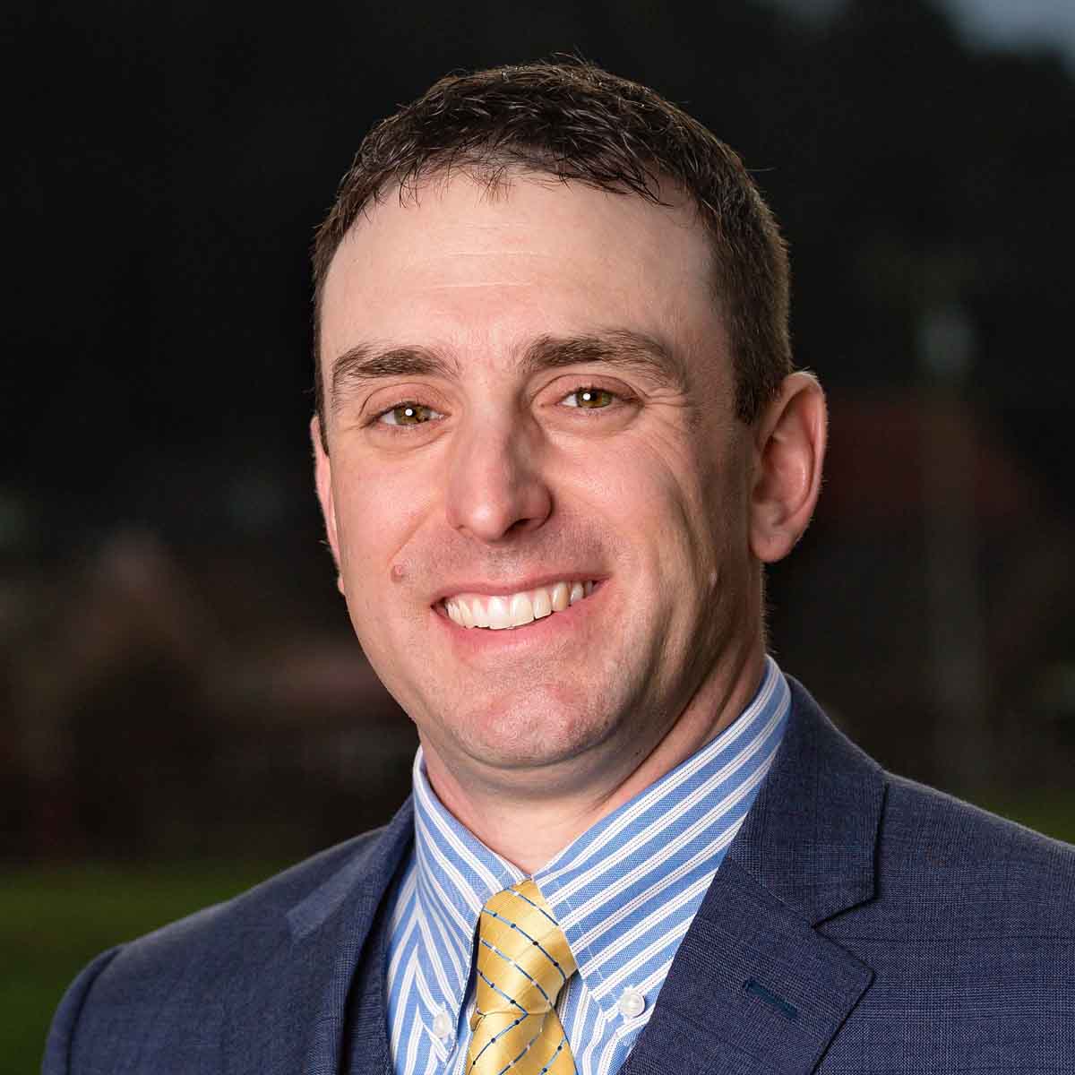 a man with short hair wearing a suit and tie