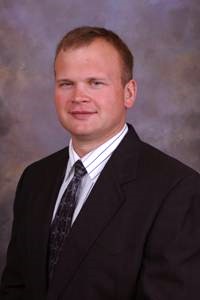 Man with short hair wearing a suit and tie