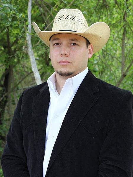 Young man in suit and tie wearing a cowboy hat