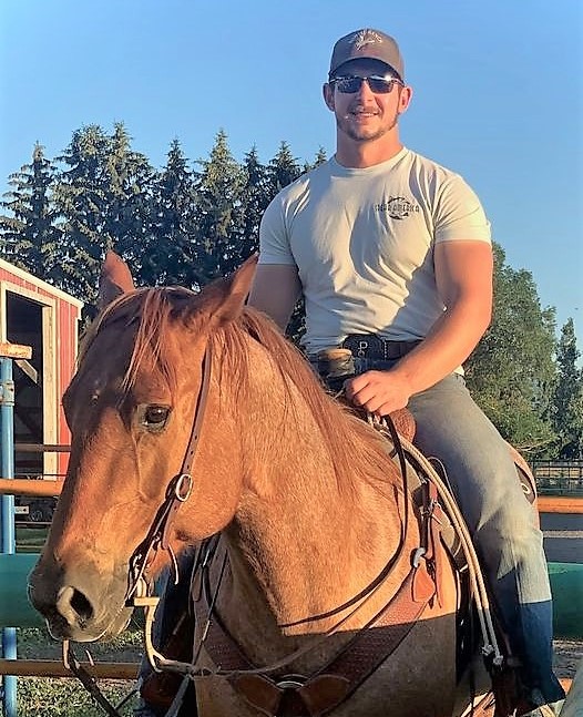 A man in a baseball cap sitting on a horse