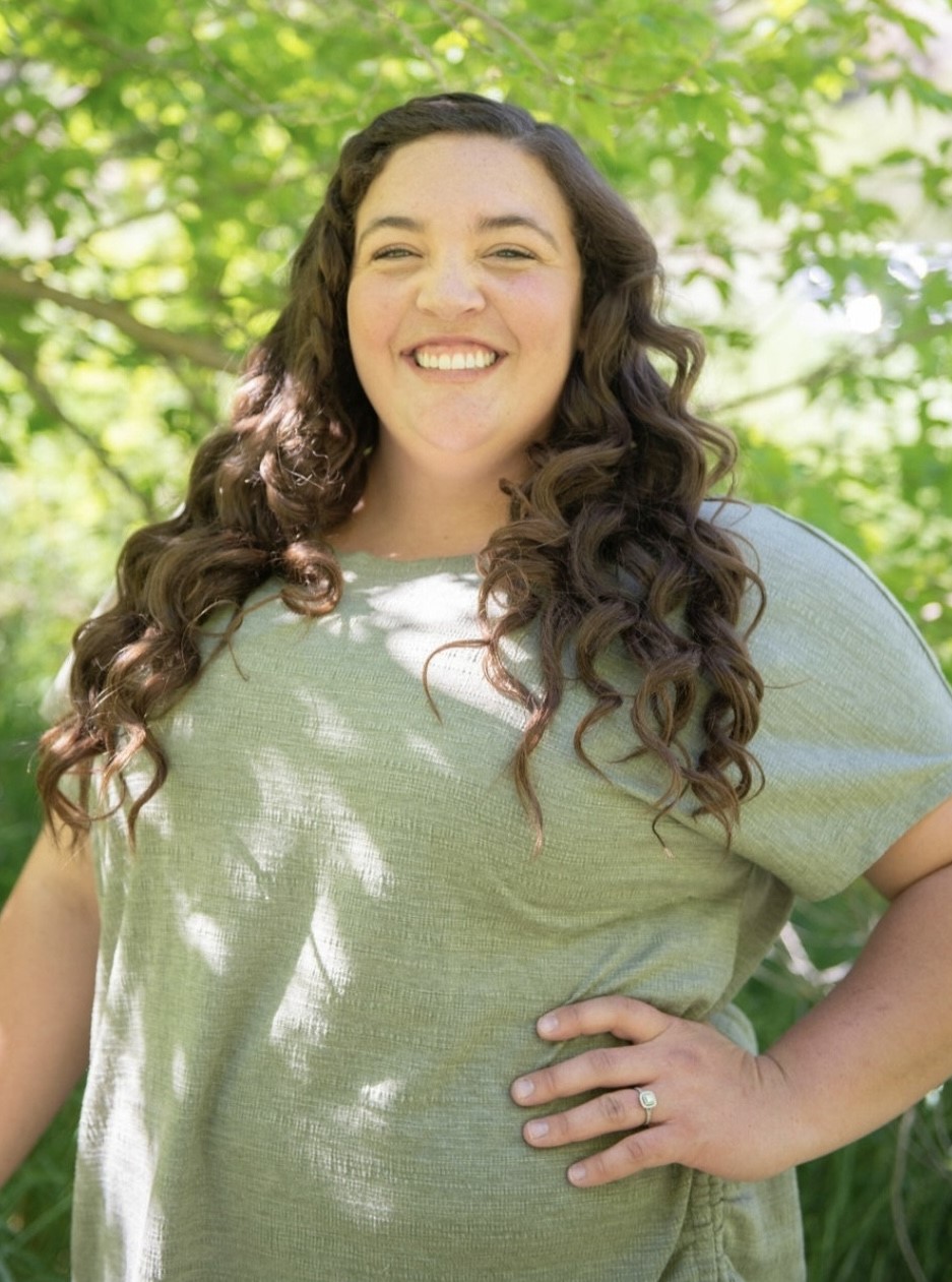 a female graduate student poses outdoors