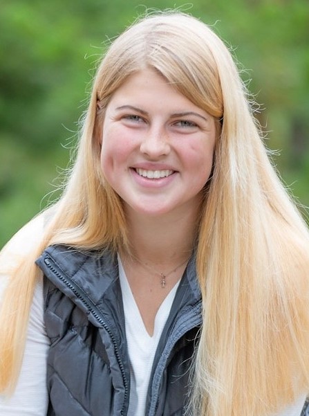 a female graduate student poses outdoors