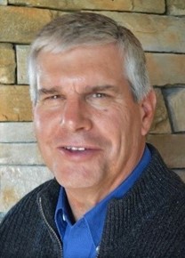 A man with gray hair faces the camera