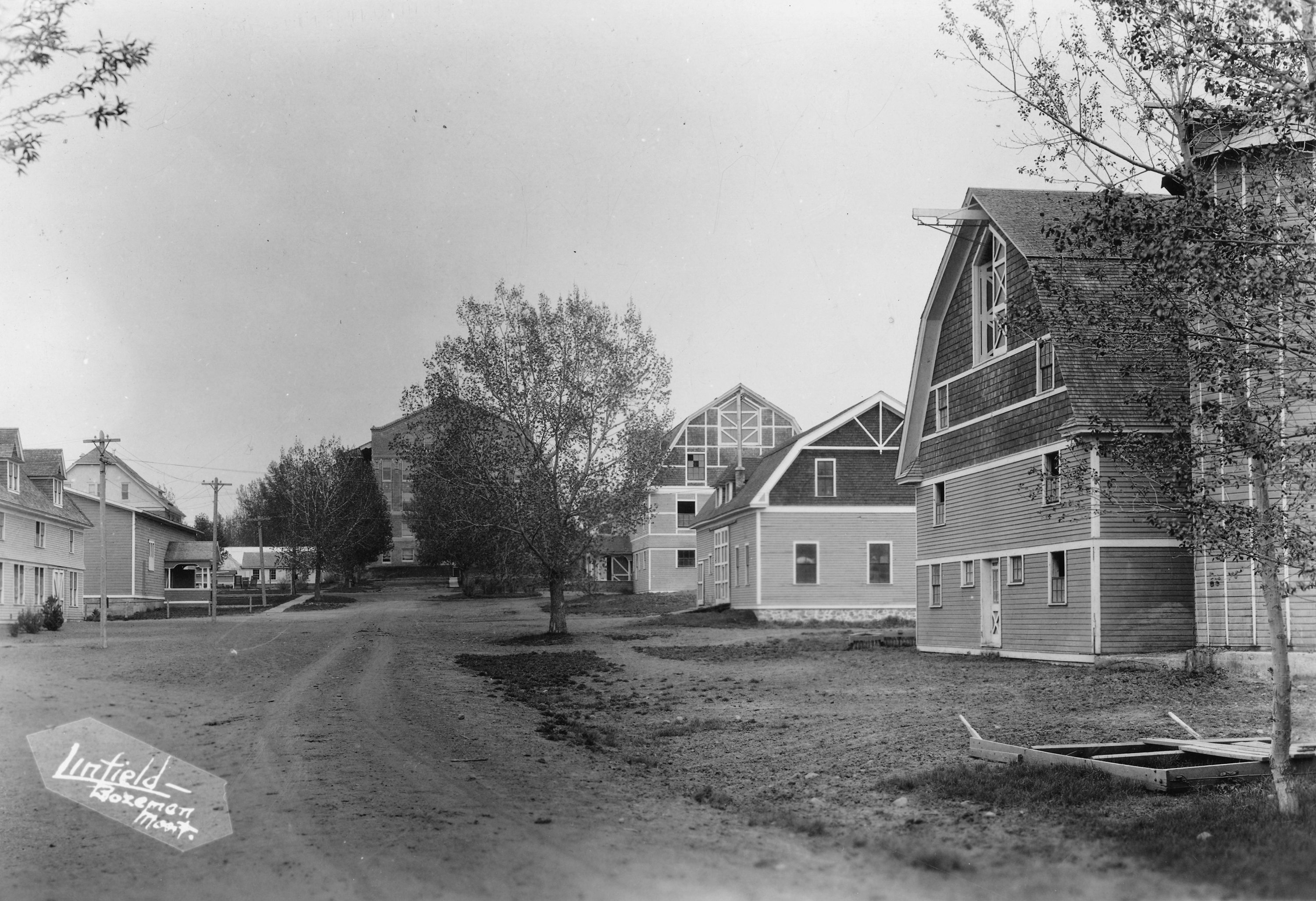 Several barns are shown lining a dirt road